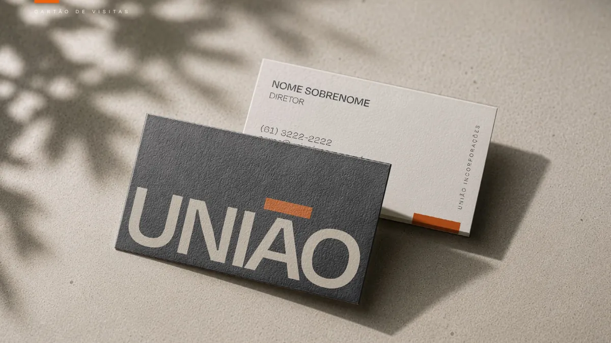 União Incorporações business cards in graphite with an orange accent